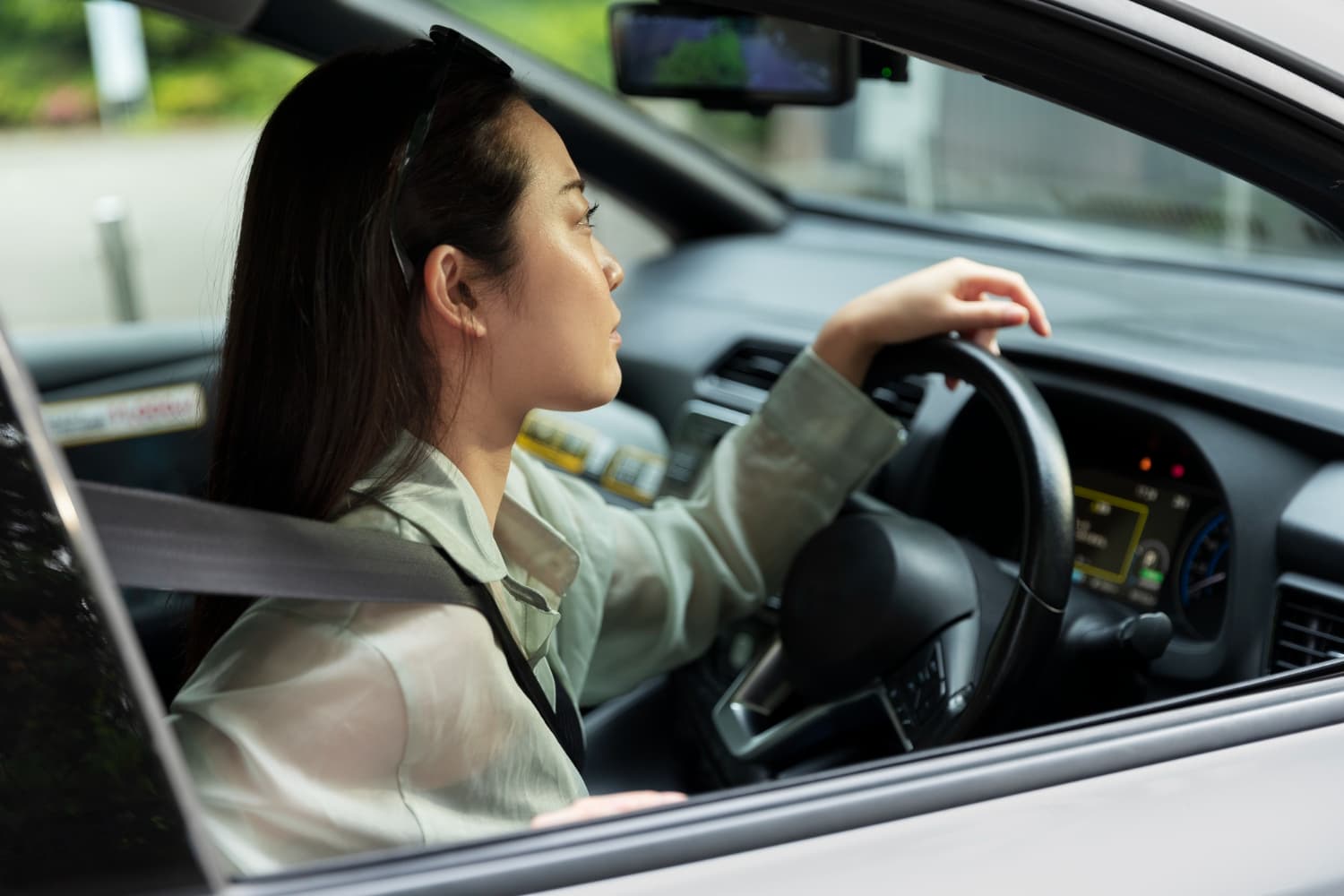 Woman in a car with her hand on the wheel